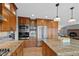 Spacious kitchen featuring stainless steel appliances, island, and ample wood cabinetry at 18 Blue Sage, Littleton, CO 80127