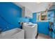 Well-lit laundry room featuring a washer, dryer, utility sink, and ample storage at 18 Blue Sage, Littleton, CO 80127