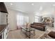 Bright living room with open floor plan, offering view into kitchen area at 4220 Headlight Rd, Strasburg, CO 80136