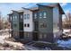 Three-story townhomes with a mix of green, white, and gray siding at 5193 Carr St, Arvada, CO 80002