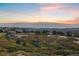 Scenic aerial view of a neighborhood nestled amidst rolling hills and lush greenery with a beautiful mountain backdrop at 6405 Kenzie Cir, Castle Pines, CO 80108