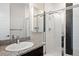 Modern bathroom with a stylish shower featuring glass doors and decorative black and white tile at 6405 Kenzie Cir, Castle Pines, CO 80108