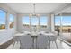 Bright dining room featuring a modern chandelier, large windows, and seating for eight at 6405 Kenzie Cir, Castle Pines, CO 80108