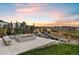 Gather around the stone fire pit with built-in seating and a lovely water feature for cozy evenings outdoors at 6405 Kenzie Cir, Castle Pines, CO 80108