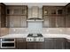 Modern kitchen featuring stainless steel appliances, custom cabinetry, and a sleek range hood at 6405 Kenzie Cir, Castle Pines, CO 80108