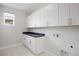 Functional laundry room with ample cabinet space, countertop, and natural light at 6405 Kenzie Cir, Castle Pines, CO 80108