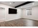 Spacious living room with a large flat-screen TV, modern flooring, and a view of the backyard through a window at 6405 Kenzie Cir, Castle Pines, CO 80108