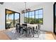 Bright dining room features a modern light fixture, neutral rug, and a large picture window at 7868 Cicero Ct, Littleton, CO 80125