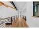 Open hallway with wood floors, metal handrails and a beamed ceiling at 7868 Cicero Ct, Littleton, CO 80125