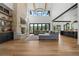 Grand living room with a stone fireplace, high ceilings, exposed beams, and large windows at 7868 Cicero Ct, Littleton, CO 80125