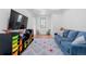 Bright playroom with a comfortable blue couch, wood floors, colorful storage and a patterned rug at 7868 Cicero Ct, Littleton, CO 80125