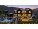 Stately rear exterior featuring a pool, outdoor living space, and expansive windows showing well-lit interiors at 7868 Cicero Ct, Littleton, CO 80125