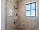 Stylish shower with a rainfall showerhead, a window and a tiled surround at 7868 Cicero Ct, Littleton, CO 80125