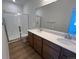 Bright bathroom featuring double sinks, hardwood floors, and a glass shower at 6648 N Nepal Ct, Aurora, CO 80019