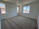 Spacious carpeted bedroom filled with natural light from two windows at 6648 N Nepal Ct, Aurora, CO 80019
