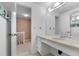 Bright bathroom featuring tile countertops and a large mirror, offering a clean and functional space at 7355 S Knolls Way, Centennial, CO 80122