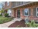 Close-up of brick home entrance with wrought iron security door and blooming flower bed at 7355 S Knolls Way, Centennial, CO 80122