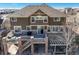 An excellent view of the spacious patio with stone and a grill on a brown two-story house at 7680 S Blackstone Pkwy, Aurora, CO 80016
