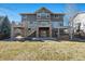 Back exterior view of a house with a deck, patio, and landscaped yard at 7680 S Blackstone Pkwy, Aurora, CO 80016