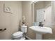 Stylish powder room with pedestal sink, decorative mirror, and neutral color scheme at 7680 S Blackstone Pkwy, Aurora, CO 80016