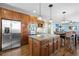 Modern kitchen with stainless steel appliances, a granite island, wooden cabinets, and hardwood floors at 7680 S Blackstone Pkwy, Aurora, CO 80016