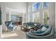 Bright living room with tall windows, plantation shutters, carpeted floors, and stylish furniture at 7680 S Blackstone Pkwy, Aurora, CO 80016