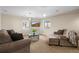 Comfortable living room with plush sofas, a glass coffee table, and bright windows at 7680 S Blackstone Pkwy, Aurora, CO 80016