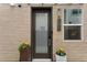 Inviting front door with brick facade, potted plants, and a welcome mat at 1836 Grove St # 108, Denver, CO 80204