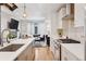 Open-concept kitchen showcasing a sink island, stainless steel appliances, and seamless flow to the living area at 1836 Grove St # 108, Denver, CO 80204