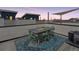 Rooftop deck features an outdoor dining set, shade, and city views at 1836 Grove St # 108, Denver, CO 80204
