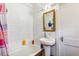 Cozy bathroom featuring white tiling, a pedestal sink, and a medicine cabinet at 1850 S Williams St, Denver, CO 80210