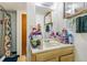 Bathroom with a vanity, mirror, open shelving with accessories, and a shower to the left at 1850 S Williams St, Denver, CO 80210