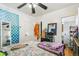 Bright bedroom featuring a ceiling fan, patterned bedding, and access to an adjacent bathroom at 1850 S Williams St, Denver, CO 80210