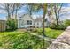 Charming home featuring a quaint front yard with lush green grass and a cozy seating area under a tree at 1850 S Williams St, Denver, CO 80210