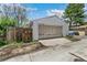 Garage featuring a roll-up door with a concrete driveway, partial fence, and greenery around at 1850 S Williams St, Denver, CO 80210