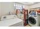 Laundry room featuring white washer and dryer units along with storage and supplies at 1850 S Williams St, Denver, CO 80210