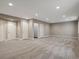 Large finished basement with neutral carpet, ample lighting, and multiple access points at 6900 W Grant Ranch Blvd # 49, Littleton, CO 80123