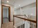 Upstairs hallway with neutral carpet, wood-trimmed doors, and white railings at 6900 W Grant Ranch Blvd # 49, Littleton, CO 80123
