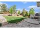 Landscaped backyard featuring a stone patio, lawn, and fencing at 10155 Charissglen Ln, Littleton, CO 80126