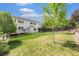 Backyard featuring a lush lawn, mature trees, and a view of the home's exterior at 10155 Charissglen Ln, Littleton, CO 80126