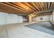 Unfinished basement with exposed wood ceiling and concrete flooring at 10155 Charissglen Ln, Littleton, CO 80126