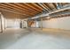 Spacious unfinished basement with exposed ceiling and staircase at 10155 Charissglen Ln, Littleton, CO 80126