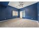Spacious bedroom featuring a ceiling fan, neutral carpet, a closet, and a window at 10155 Charissglen Ln, Littleton, CO 80126