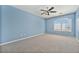 Light-filled bedroom with a ceiling fan, carpet, and a large arched window at 10155 Charissglen Ln, Littleton, CO 80126