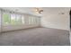 Spacious empty room with carpet flooring, large windows with plantation shutters, and ceiling fan at 10155 Charissglen Ln, Littleton, CO 80126