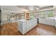 Eat-in kitchen boasts an island cooktop, stainless appliances, and white cabinetry at 10155 Charissglen Ln, Littleton, CO 80126