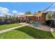 Charming backyard features a brick house, patio, lawn, and shade sail for outdoor relaxation at 1840 S Grant St, Denver, CO 80210