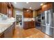 Well-lit kitchen showcasing wood cabinets, stainless steel appliances, granite counters and hardwood floors at 1840 S Grant St, Denver, CO 80210
