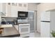 Modern kitchen featuring white cabinets, mosaic tile, and stainless steel appliances at 3558 Pecos St, Denver, CO 80211