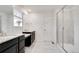 Bright bathroom featuring dual sinks, granite countertops, and a glass shower at 12777 Clearview St, Firestone, CO 80504
